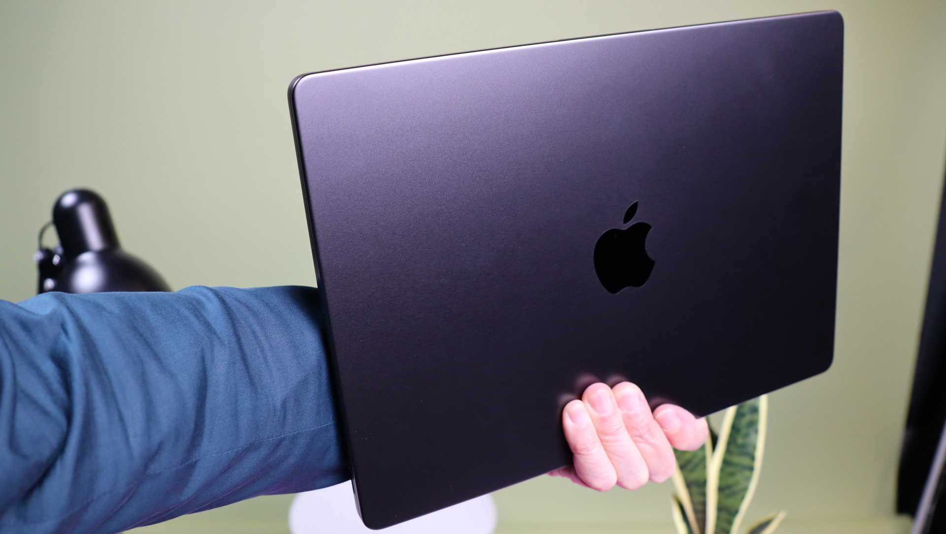 MacBook Pro 14 M3 Max being held in an outstretched arm