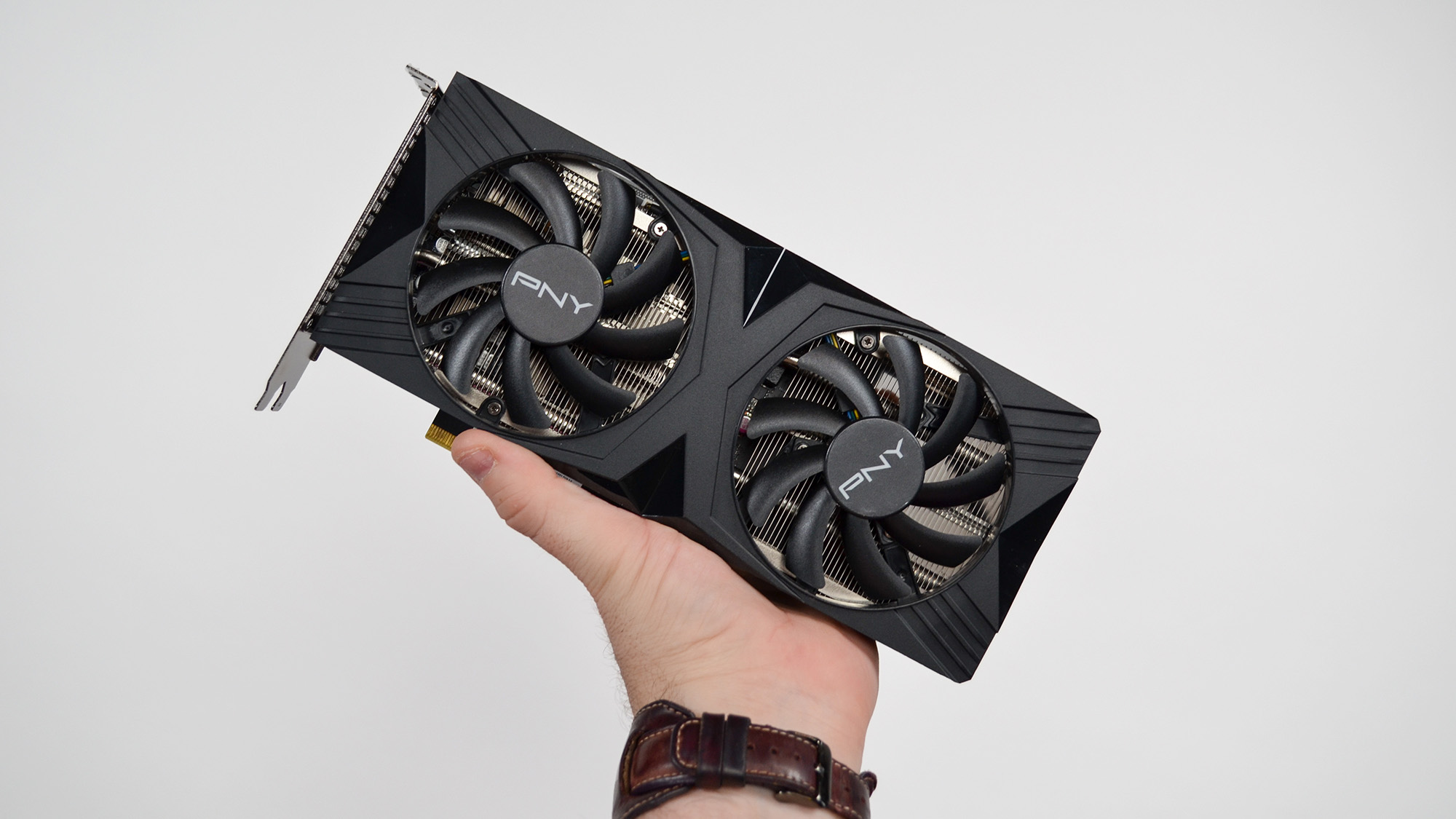 Person holding a PNY GeForce RTX 4060 Ti graphics card in their hand.